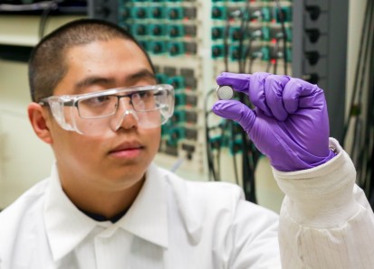 ORNL postdoctoral researcher Runming Tao, pictured with a coin cell battery, led an effort to discov