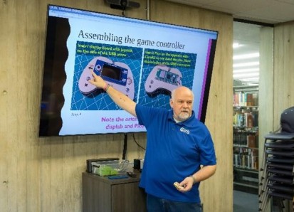 Thomas Proffen presents a slide on assembling a game controller 