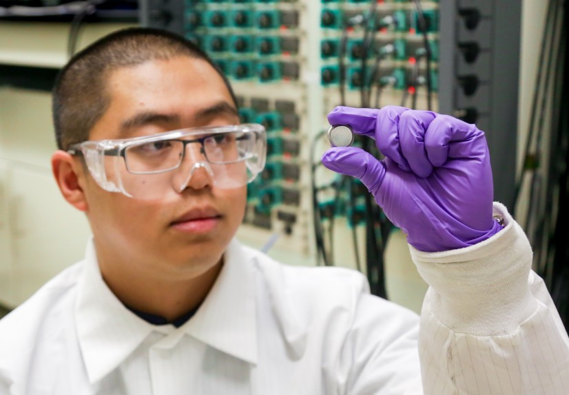 ORNL postdoctoral researcher Runming Tao, pictured with a coin cell battery, led an effort to discov
