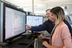 ORNL researchers Garrett Granroth and Fahima Islam observe data filtered through their new software, which gives researchers access to data with five times more resolution than traditional data reduction methods. (Credit: ORNL/Genevieve Martin)