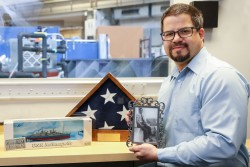 ORNL researcher Matt Stone keeps a scale model of the USS Indianapolis in his office as a tribute to his grandfather, who served aboard the ship during its top-secret mission to deliver weapons that would be used to end World War II. In its infancy, neutron scattering played a role in developing those weapons as part of Manhattan Project. Today, Stone uses neutrons to study materials that are used to improve life around the world. (credit: ORNL/Genevieve Martin)