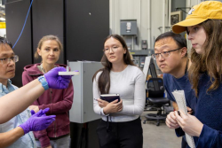 Lisa Debeer-Schmitt, a neutron scattering scientist at ORNL, holds a sample mount while explaining sample preparation and positioning to students, including Michelle Sandag, at the General Purpose Small-Angle Neutron Scattering Diffractometer. Credit: Alo