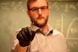 Colorado State University researcher Gavin Hester holds a sample of ytterbium silicate. He and his colleagues are using neutrons at Oak Ridge National Laboratory to study the material to better understand an unusual quantum phase called a Bose-Einstein condensate. (Credit: CSU/Daniel Shaw)