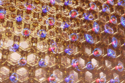 A honeycomb lattice material shows an arrangement of cobalt atoms, with arrows up (red) and down (bl