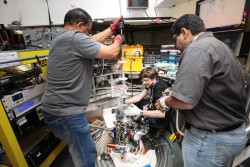 Jonathan Morris, center, works with ORNL scientists Saad Elorfi and Arnab Banerjee to retrieve his ice crystal from a cryogenic chamber at the Spallation Neutron Source’s ARCS instrument. (Credit: ORNL/Genevieve Martin)