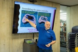 Thomas Proffen presents a slide on assembling a game controller 