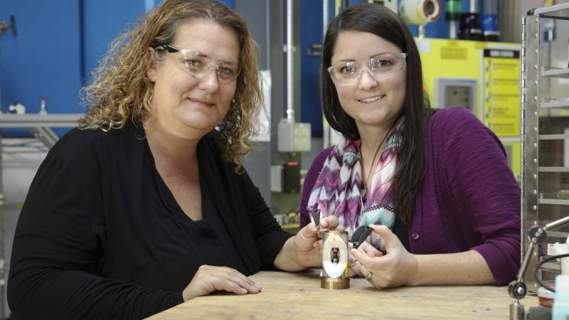 ORNL’s Bianca Haberl and Amy Elliott hold 3D printed collimators next to a pressure cell loaded with a sample. These collimators were developed as a collaboration between the lab’s Neutron Sciences Directorate and Manufacturing Demonstration Facility. (Image credit: ORNL/Genevieve Martin)