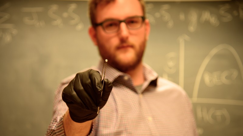 Colorado State University researcher Gavin Hester holds a sample of ytterbium silicate. He and his colleagues are using neutrons at Oak Ridge National Laboratory to study the material to better understand an unusual quantum phase called a Bose-Einstein condensate. (Credit: CSU/Daniel Shaw)